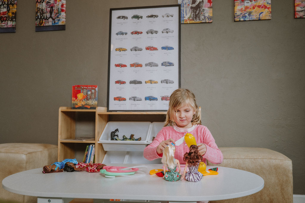 Young girl playing with dolls